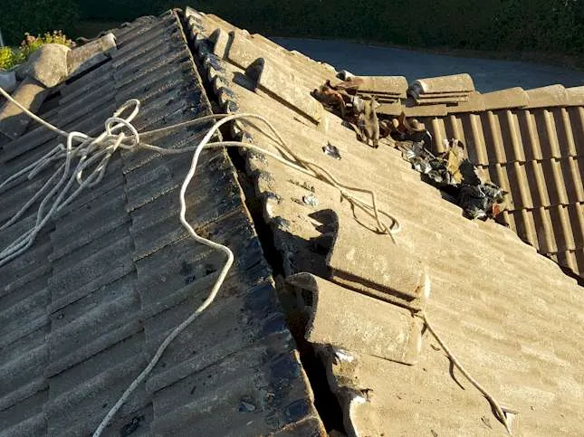 Gros plan sur un solin zinc fissuré autour d'une cheminée dans le Doubs